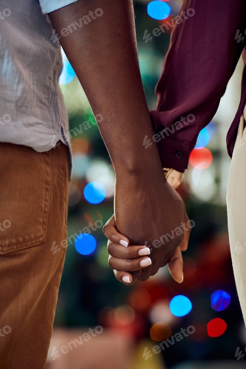 Preview: Close-up of black couple holding hands while spending Christmas together.