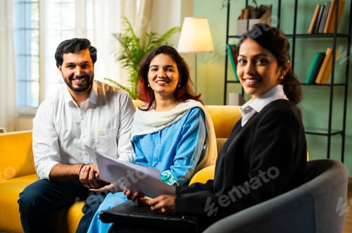 Preview: Young Indian happy couple receiving document from female corporate consultant, thumbs up