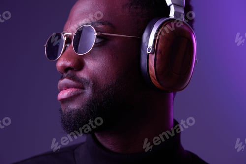 Preview: Fashionable Black man wearing stylish headphones and sunglasses, conveying confidence and style