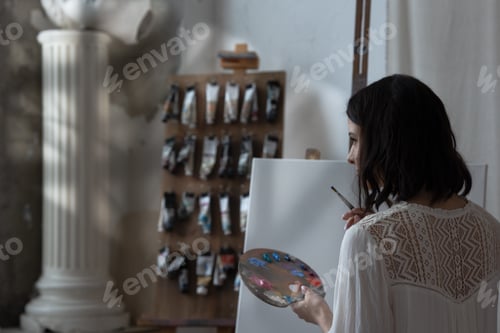 Preview: An artist girl in an art workshop with a palette in her hands