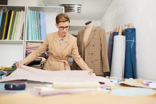 Preview: Tailor working with fabric in workshop