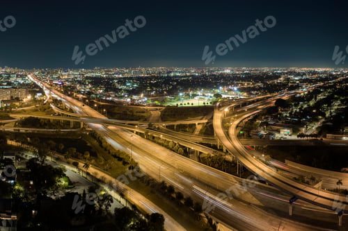 Preview: Aerial view of american freeway intersection at night with fast driving cars and trucks