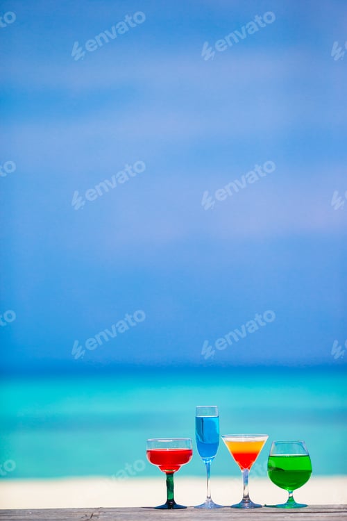 Preview: Four colorful exotic tasty cocktails background turquoise sea