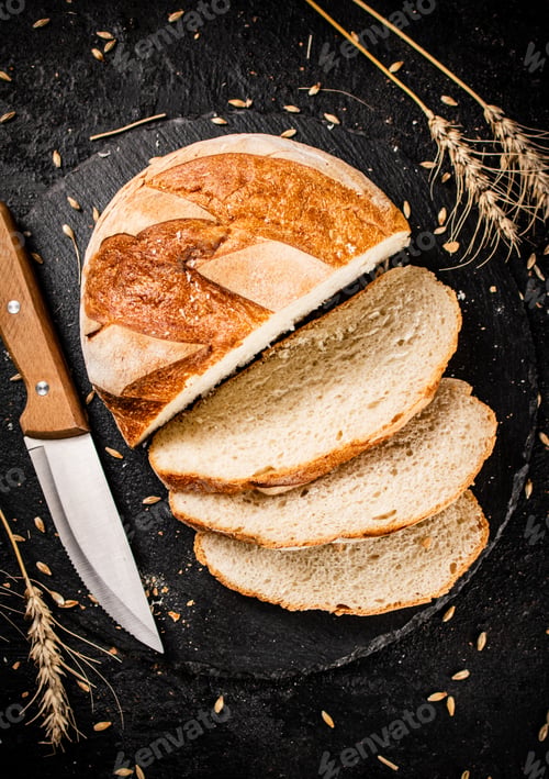 Preview: Sliced on a stone board wheat bread with grains.