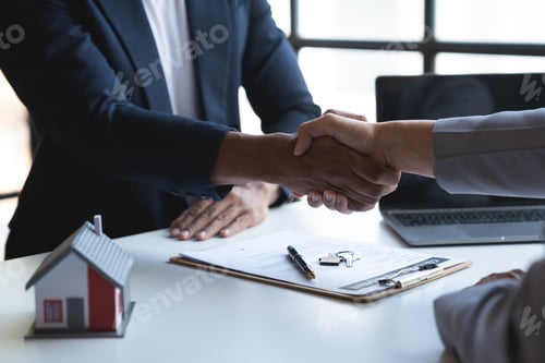 Preview: Two young Asian businessmen shake hands after signing a contract to invest in a village project. rea