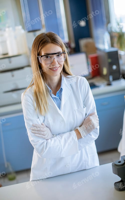 Preview: Female scientist in white lab coat standing in the biomedical lab