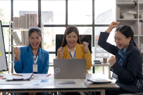 Preview: Team of young Asian business woman using laptop computer in the office, getting good new