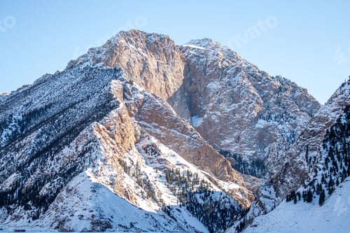 Preview: Snowcapped mountains and pine trees in a mountain valley