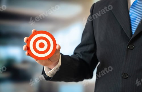 Preview: A businessman holds a target in his hand. Goal setting and business management.
