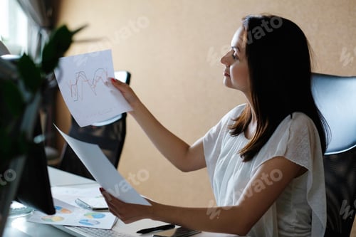 Preview: Woman Analyzes Data Charts in Office Setting