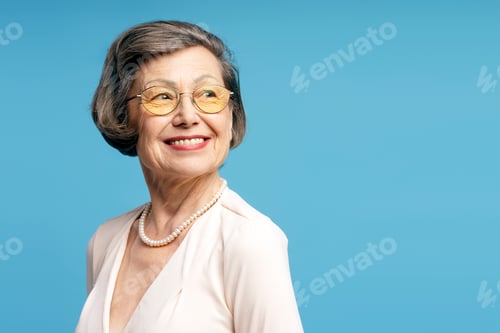 Preview: Smiling Senior Woman Posing Against Blue Background