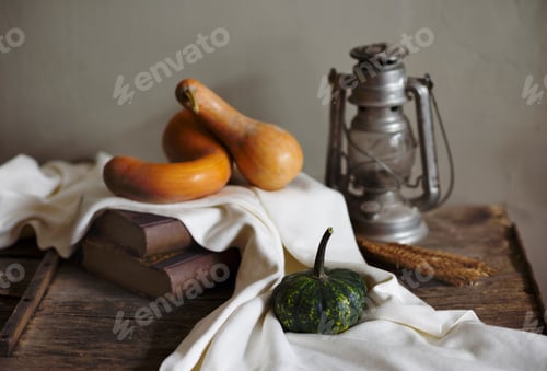 Preview: Autumn still life with vintage lantern and pumpkin vegetable on rustic wooden table.