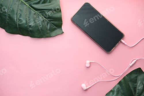 Preview: smart phone with empty screen, earphone on pink background