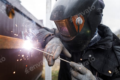 Preview: Shielded metal arc welding. Worker welding metal with electrodes, wearing protective helmet