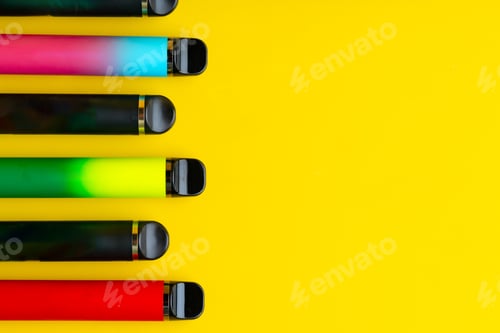 Preview: Colorful disposable electronic cigarettes on yellow background