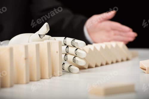 Preview: partial view of woman pushing wooden bricks while robotic hand preventing row from falling