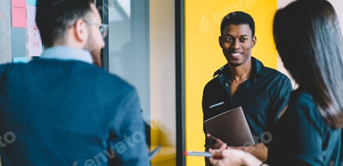 Preview: Happy African American worker discussing project with partners