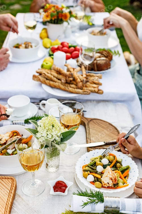 Preview: People Share Meal Together at Long Outdoor Table