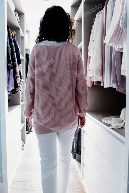 Preview: Female strolling through her wardrobe, wearing a bright pink blazer.