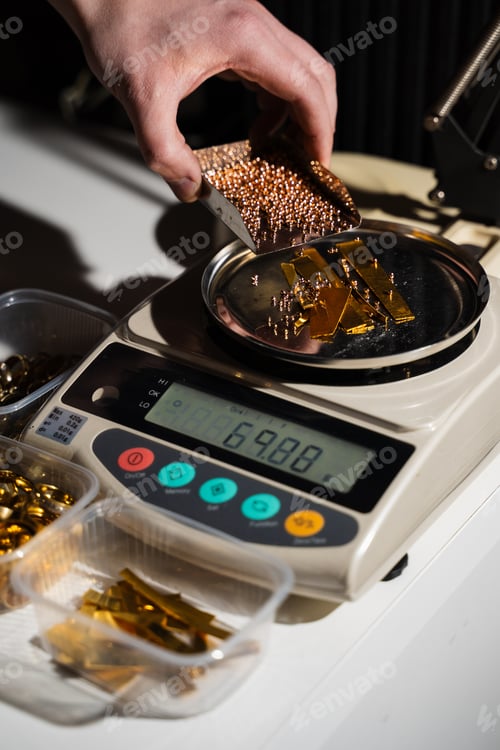 Preview: Jeweler weighing mixed gold beads pieces and scrap material.