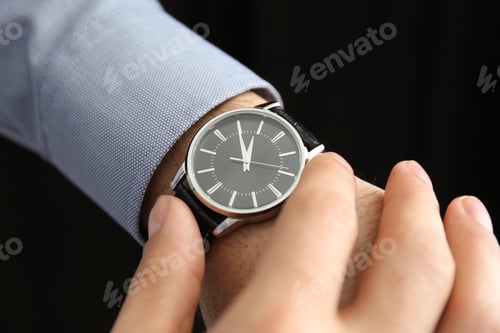 Preview: Man with luxury wrist watch on black background, closeup