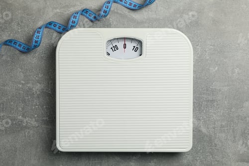 Preview: Scales and measuring tape on gray background. Weight loss concept