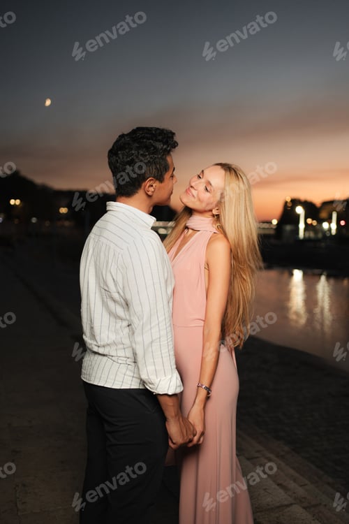 Preview: Couple embracing during sunset along the serene waterfront path