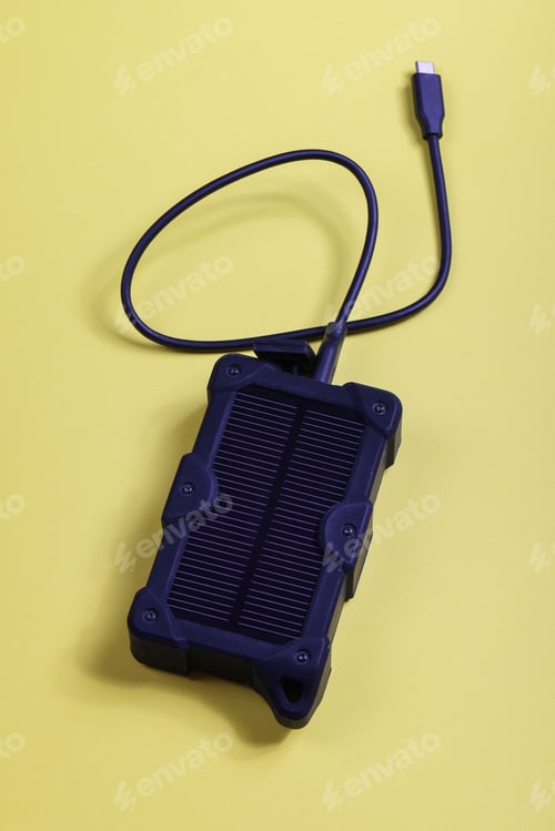 Preview: cheapest source of electricity. power box, portable solar battery for phone on yellow background.