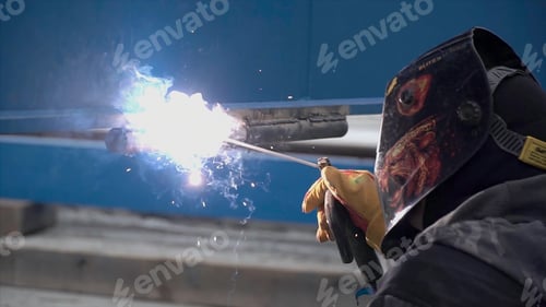 Preview: Arc welding of a steel in construction site. Clip. Man in mask is welded on construction site