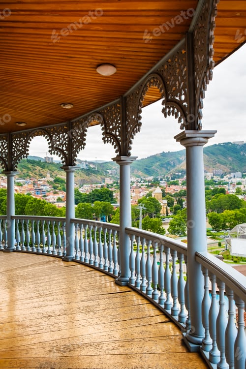 Preview: Carved wooden balcony with view to Rike park and colorful buildings in historical Tbilisi, Georgia