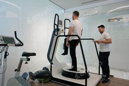 Preview: Patient performing one-leg balance exercise on equipment with physiotherapist