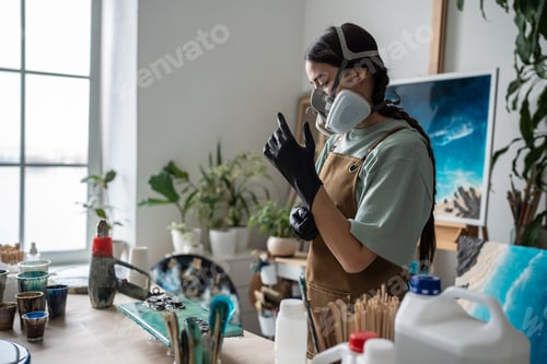 Preview: Female artist concentrates, enters state of focus, preparing for hard work on epoxy resin painting.