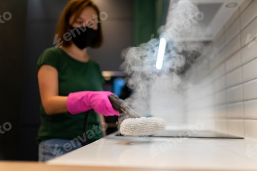 Preview: Woman cleaning kitchen furniture with steam cleaner
