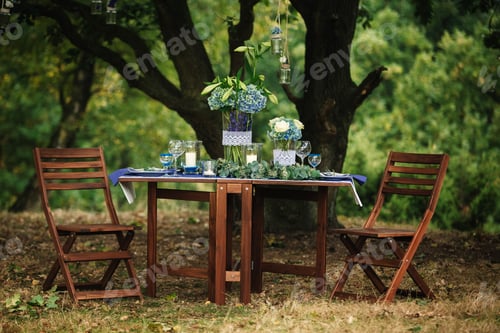 Preview: Decor. Details. Wedding decorations. On the wooden table in the woods there is a flower arrangement