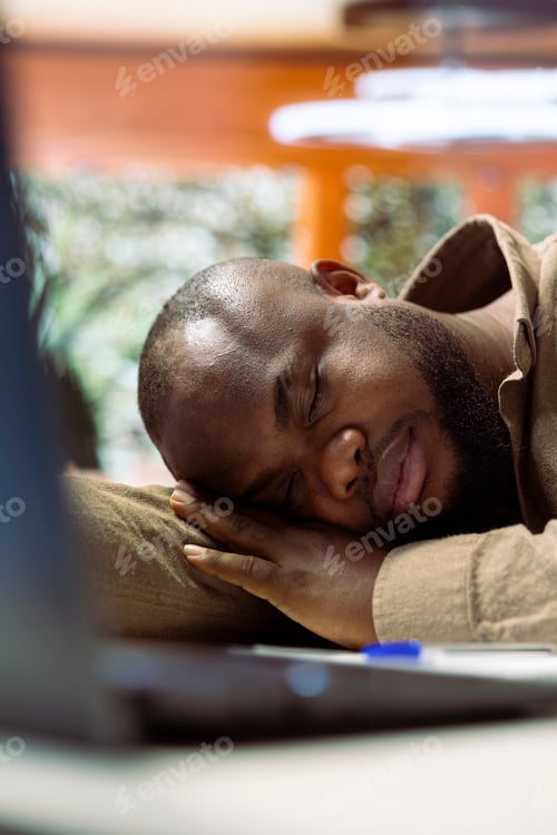 Vista previa: Tired entrepreneur takes a nap on laptop at his home office setup
