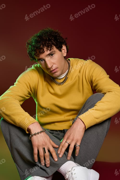 Preview: Stylish man exudes charm in vibrant attire with an artistic background