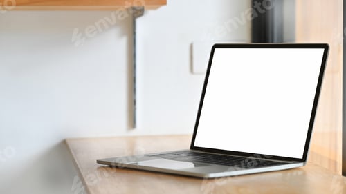 Preview: Empty screen laptop computer on wood desk with isolated white screen.