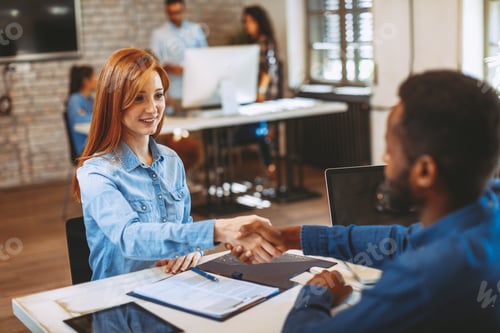 Preview: Young woman signing contracts and handshake with a manager