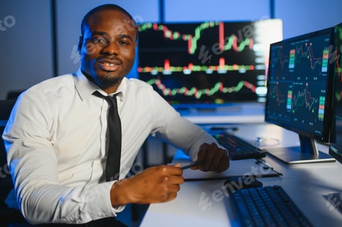 Preview: African american male stock trader or broker working at stock exchange office using computer