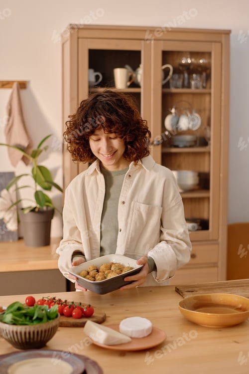 Preview: Curly Haired Woman Putting Baking Tray Down on Table