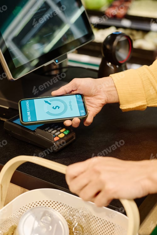 Preview: Customer paying with smartphone in supermarket