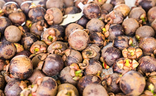 Preview: Fresh mangosteen for sale at an outdoor market.