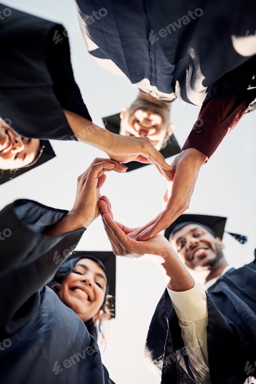 Preview: Closeup shot of a group of students joining their hands together in a circle on graduation day