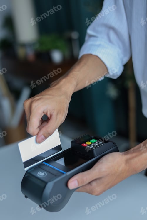 Preview: A person using a Point of Sale (POS) terminal to process a payment with a credit or debit card.