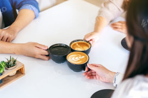 Preview: Closeup image of people enjoyed drinking and clinking coffee cups on the table in cafe