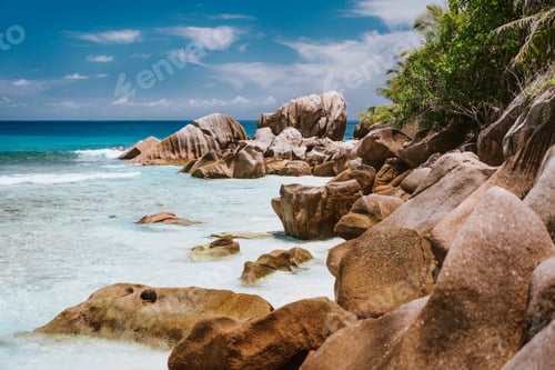 Preview: La Digue, Seychelles Islands. Turquoise ocean lagoon at popular Anse Cocos beach with granite rock