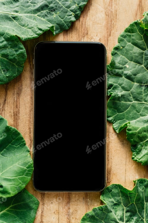 Preview: Smartphone next to green leafy vegetables