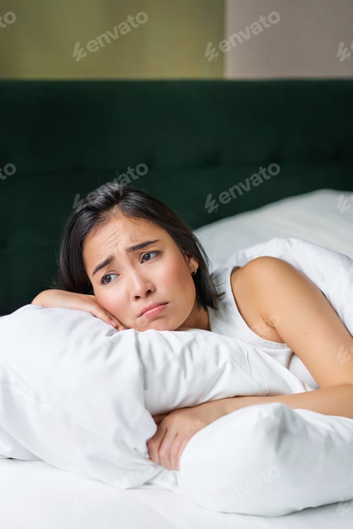 Preview: Sad and gloomy asian girl lying in her bed, grimacing and crying, feeling upset, spending time in