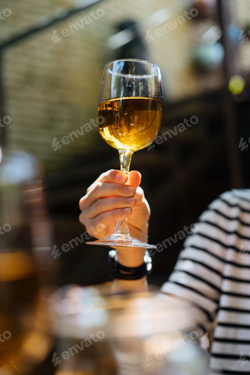 Preview: Woman holding glass of wine