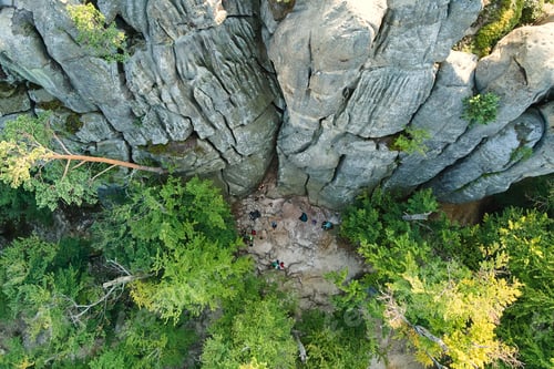 Preview: Aerial view of bright landscape with green forest trees and big rocky boulders between dense woods